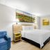 Days Inn by Wyndham Salina South room with bed, sofa, wall art and bathroom doorway in Salina
