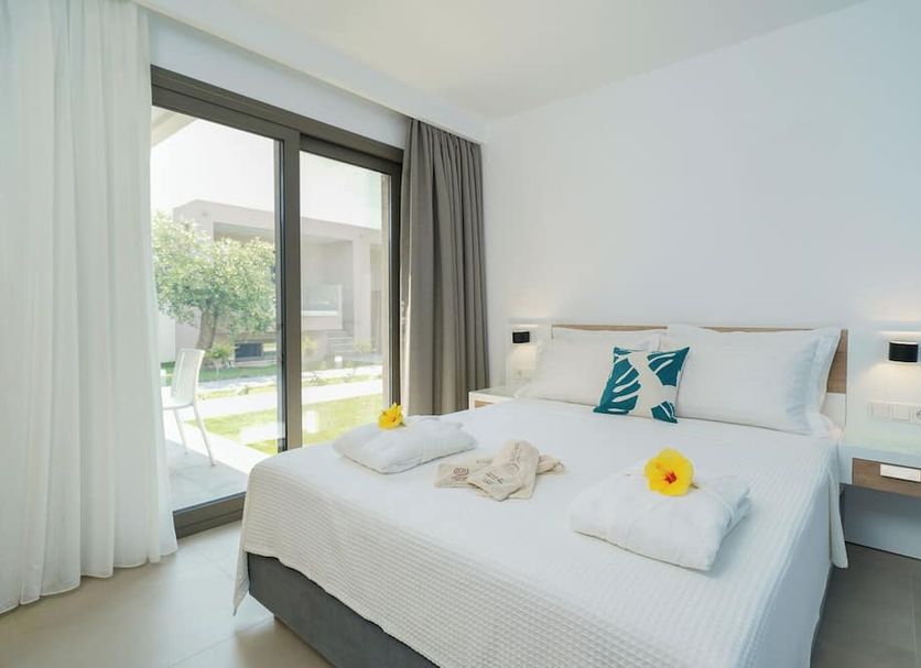 Thassos Olivia Resort in Potos bedroom with king bed and balcony view to garden