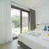 Thassos Olivia Resort in Potos bedroom with king bed and balcony view to garden
