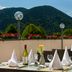 Karma Bavaria in Schliersee: terrace dining with mountain views, set tables, flowers, and umbrellas