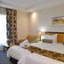 City Lodge Hotel Grandwest in Cape Town room with twin beds, bedside lamps and patterned curtains