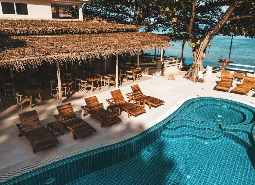 Blue Turtle Hotel Samui in Ko Samui: poolside lounge chairs beside a curving pool overlooking the sea