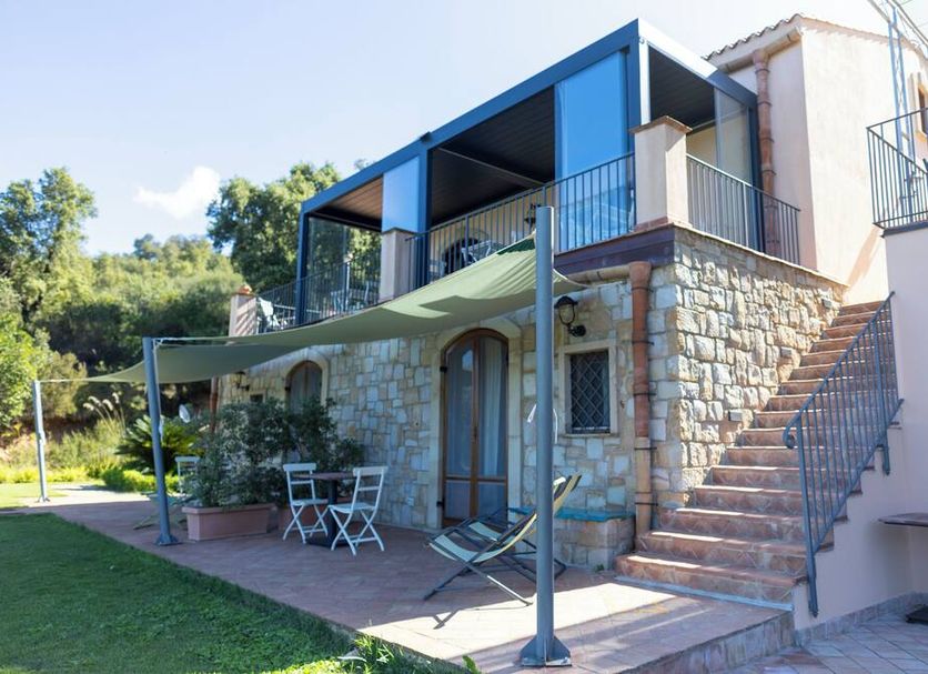 B&B Le Ginestre in Cefalù, stone terrace with shaded seating, lounge chairs and exterior stairs