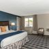 Rockport Inn and Suites guest room with king bed, window view, desk and chair in Rockport