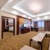 Haili Garden Hotel Guangzhou suite with sofa, coffee table, TV, desk and bedroom doorway