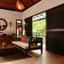 The Banjaran Hotsprings Retreat in Ipoh: open-air villa lounge with wooden sofa, coffee table and forest view