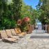 Private Sea Temple Studio 423 in Palm Cove: stone patio loungers lead to a tropical gate and sea view