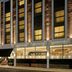 The Cura Hotel Kensington, London exterior with illuminated windows and glass-fronted ground floor