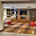 Four Points by Sheraton Nashville Airport lounge with TV, fireplace, and colorful patterned carpet