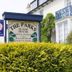 The Parks Guest House in Minehead with sign, white facade, and blue wrought-iron balcony