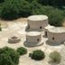 Lazaros Stonehouse in Larnaca with round stone cottages amid trees and a dry landscaped courtyard