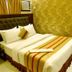 Housez 43 Kolkata guest room with double bed, tufted headboard, air conditioner and gold patterned walls