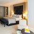 La Réserve Resort in Knokke Heist guest room with king bed, bench, armchair and built-in wardrobes