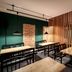 Romantik Hotel Hirschen in Parsberg dining area with wooden tables, black chairs, and green walls