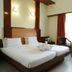 Fabhotel Prime Chennai Deluxe room with twin bed, seating area and large window in Chennai