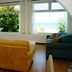 Bravo Beach Hotel Vieques guest lounge with sofa, armchair, TV and ocean-view windows