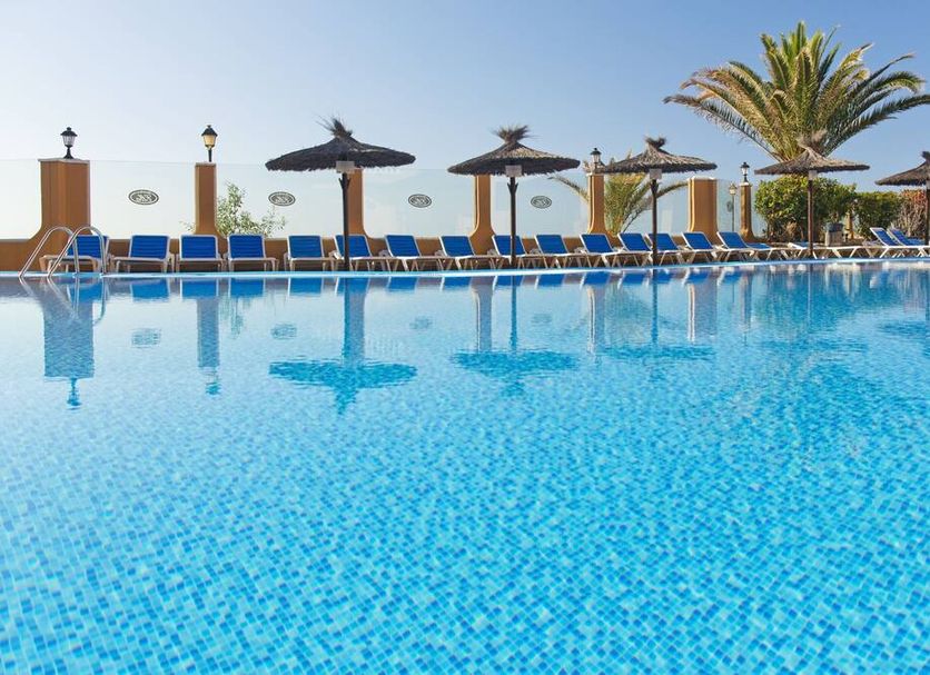 Elba Castillo San Jorge & Antigua Suite Hotel pool with sun loungers and palm trees in Antigua