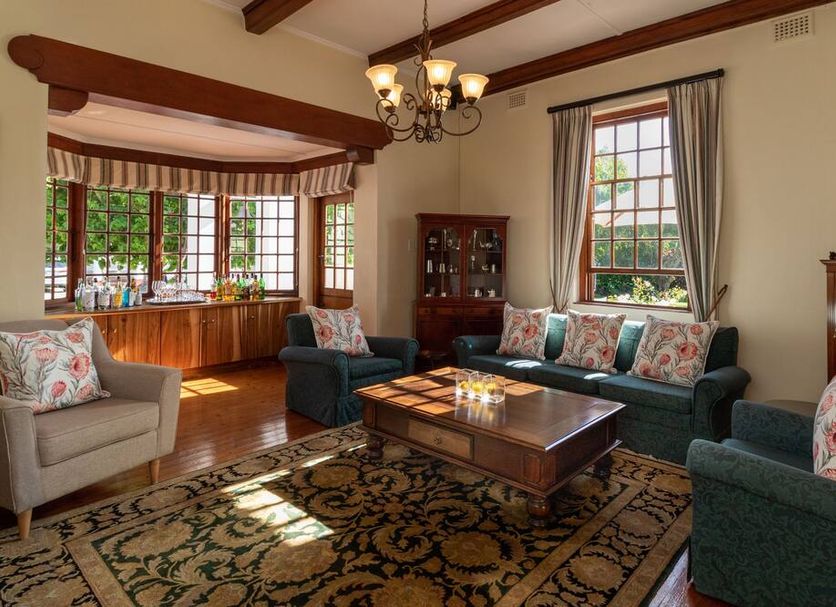 Glen Avon Lodge Boutique Hotel in Cape Town lounge with sofas, chandelier, fireplace and large windows
