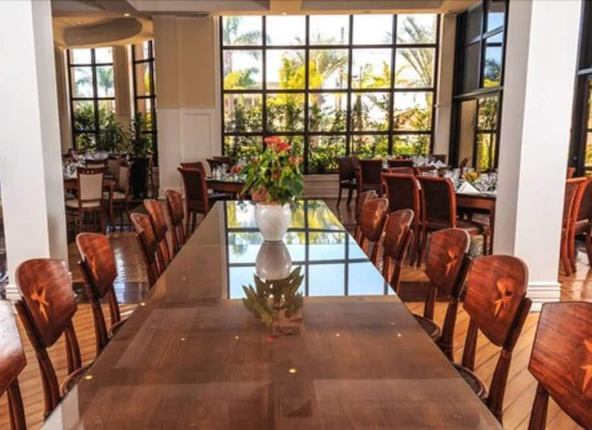 Marques Plaza Hotel in Pouso Alegre dining room with long table and large windows