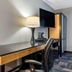 Spark By Hilton Evansville Downtown desk area with lamp, TV and chair in a guest room