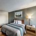 HomeTowne Studios by Red Roof Austin room with bed, kitchenette and lamp