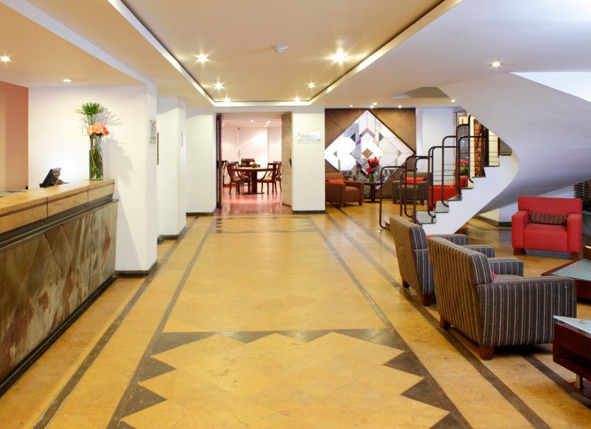 Hotel Estelar de La Feria Bogotá lobby with reception desk, seating area and staircase