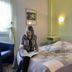 Logis Auberge des Vieux Chênes in La Chapelle-aux-Brocs guest room with a woman reading on the bed