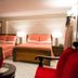 Constellation Hotel in Port Au Prince guest room with two double beds, red seating, and bedside lamps