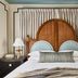 Zelda Dearest in Asheville guest room with arched wood headboard, twin lamps, and striped pillows