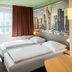 B&B Hotel Frankfurt-West room with two single beds and cityscape wall art in Frankfurt am Main