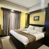 Hotel The Capital in Dhaka guest room with king bed, window curtains, desk and TV