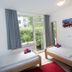 Basement Rotherbaum Hamburg twin room with two beds, red rug, and garden-facing window