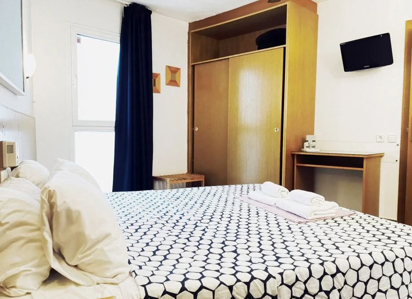 La Caleta de Tamariu room with double bed, wardrobe, desk and wall-mounted TV in Tamariu