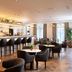 Holmes Hotel London bar and lounge in London with bar stools, round tables, and seating area