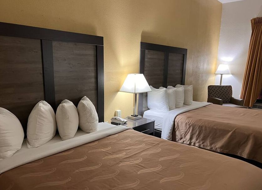 Quality Inn Maysville guest room with two beds, lamps, and window with curtains