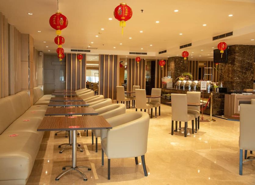Orchardz Hotel Industri Jakarta lounge with dining tables, beige seating, and red lantern decor