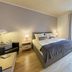 Arador City Hotel in Bad Oeynhausen bedroom with double bed, bedside lamps, chair, and large window
