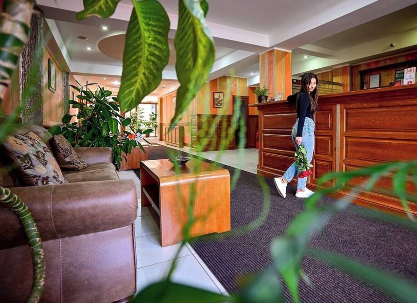 Hotel Class Hermannstadt lobby in Sibiu with front desk, seating area, and indoor plants