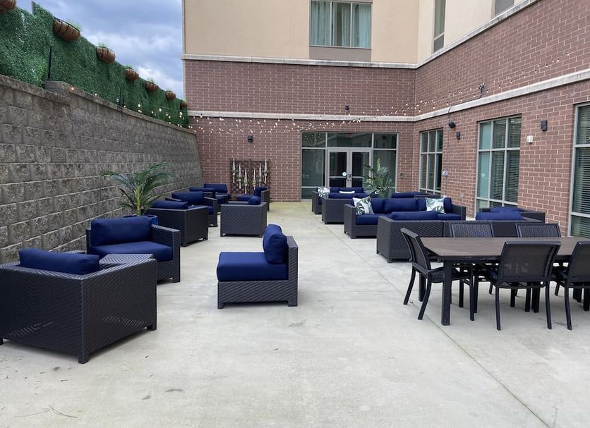 Hampton Inn & Suites Charlotte Ballantyne patio with outdoor seating and tables beside the hotel
