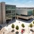 Hotel Les Portes D'Or in Nancy, modern hotel exterior with plaza, trees, and adjacent glass building