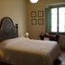 Agriturismo La Capitata in Pian di Scò bedroom with bed, lamps, wooden desk and open window
