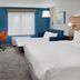 Holiday Inn Express Kansas City - At The Legends By IHG room with two beds, desk, TV and blue accent wall