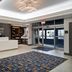 Hampton Inn New York-JFK lobby in Queens with front desk, patterned rug and glass entry doors
