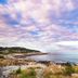 Emerson Inn By The Sea in Rockport with rocky coastline and ocean view under a colorful sky