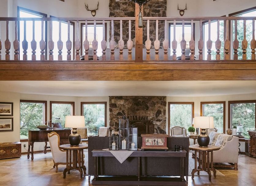 Enzian Inn in Leavenworth lobby with stone fireplace, balcony railing, and seating area