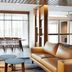 Fairfield Inn & Suites by Marriott Sheboygan lobby with leather sofa, side tables, dining area and stone wall