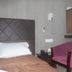 Hotel Meena Paradise, Visakhapatnam: guest room with bed, purple chair, wall mirror and side table