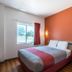 Motel 6 Junction City, KS guest room with queen bed, window view, and orange accent wall