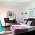 Le Neoulous in Le Boulou guest room with bed, desk, TV and framed wall art