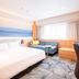 Richmond Hotel Miyazaki Ekimae guest room with bed, sofa, desk and large window in Miyazaki